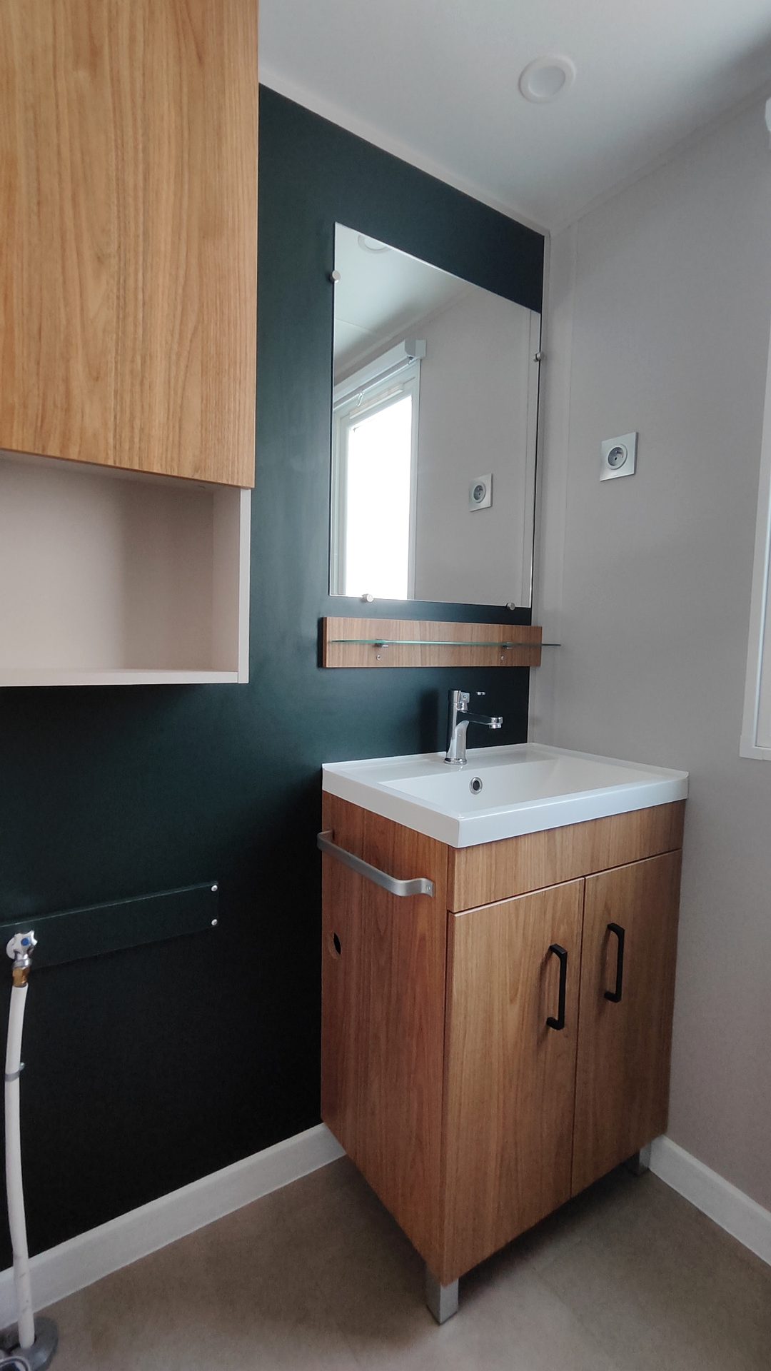 Vasque, miroir et rangements dans l'une des salles d'eau